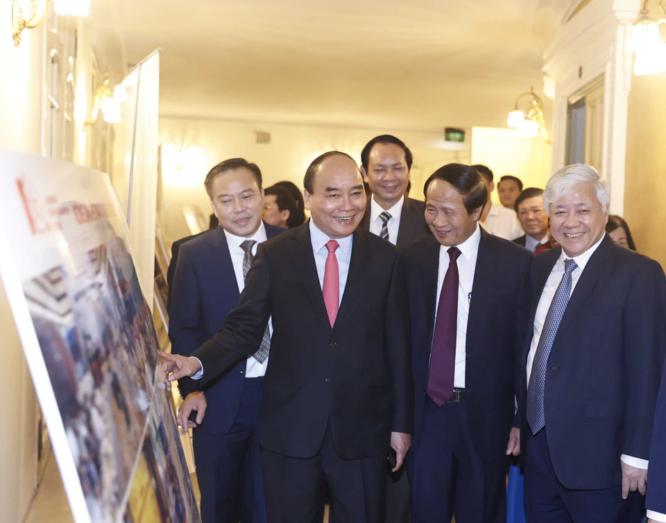 Chủ tịch nước Nguyễn Xuân Phúc và các đại biểu xem trưng bày ảnh tại buổi lễ. (Ảnh: Thống Nhất/TTXVN)