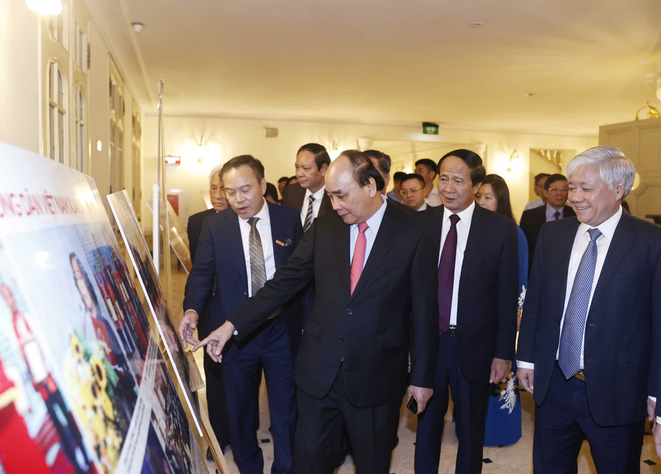 Chủ tịch nước Nguyễn Xuân Phúc và các đại biểu xem trưng bày ảnh tại buổi lễ. (Ảnh: Thống Nhất/TTXVN)