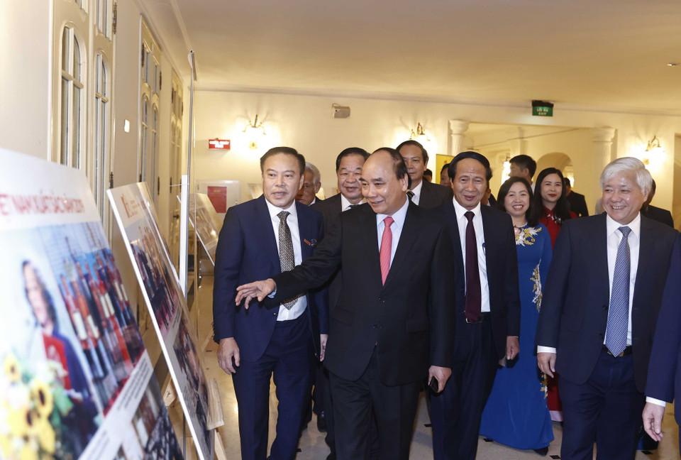 Chủ tịch nước Nguyễn Xuân Phúc và các đại biểu xem trưng bày ảnh tại buổi lễ. (Ảnh: Thống Nhất/TTXVN)