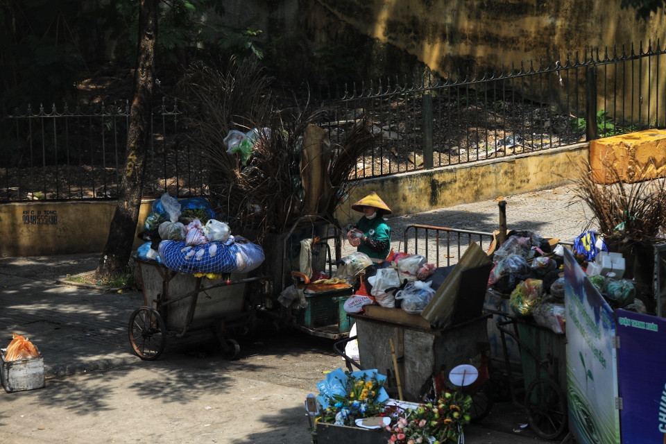  Một công nhân vệ sinh vẫn phải làm việc dưới nắng nóng gay gắt. (Ảnh: Tuấn Anh/TTXVN)