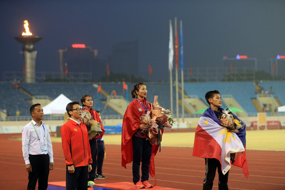 Phó Thủ tướng Vũ Đức Đam cùng các VĐV làm lễ cử hành Quốc thiều Việt Nam tại buổi lễ trao huy chương nội dung chạy 5000m nữ cho các VĐV Nguyễn Thị Oanh (HCV), Phạm Thị Hồng Lệ (HCB).(Ảnh: Huy Hùng/TTXVN)