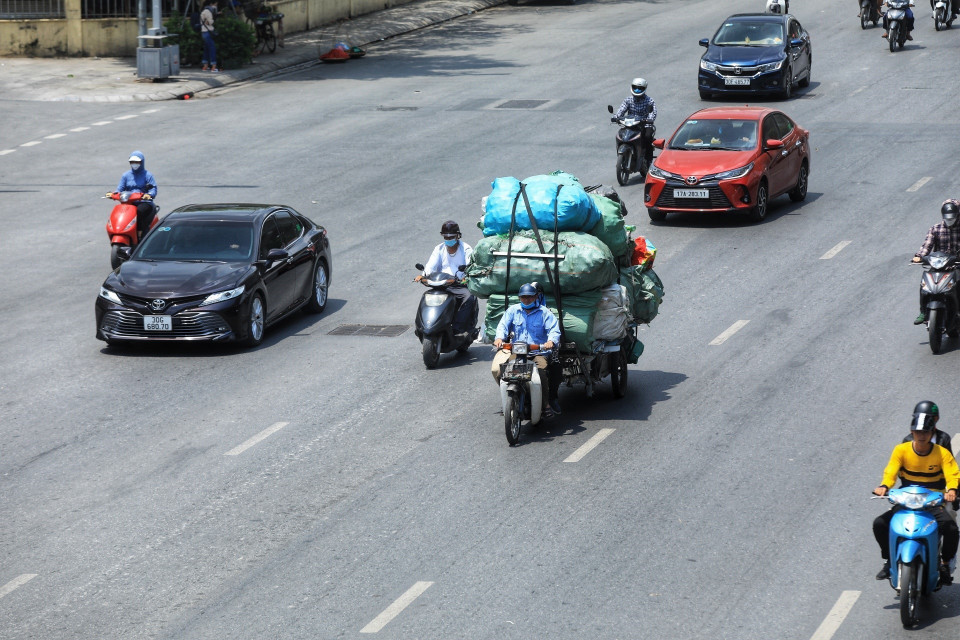 Nắng nóng gây khó khăn vất vả cho nhiều người khi di chuyển ngoài trời. (Ảnh: Tuấn Anh /TTXVN)