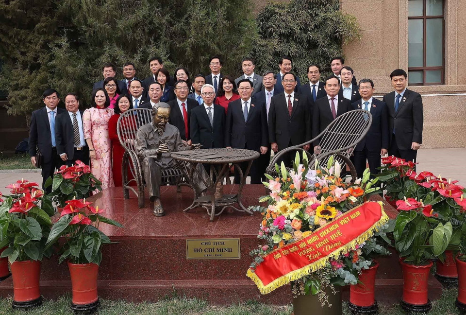Chủ tịch Quốc hội Vương Đình Huệ với các đại biểu chụp ảnh lưu niệm tại tượng Chủ tịch Hồ Chí Minh trong khuôn viên Đại sứ quán Việt Nam ở Trung Quốc. (Ảnh: Nhan Sáng/TTXVN)