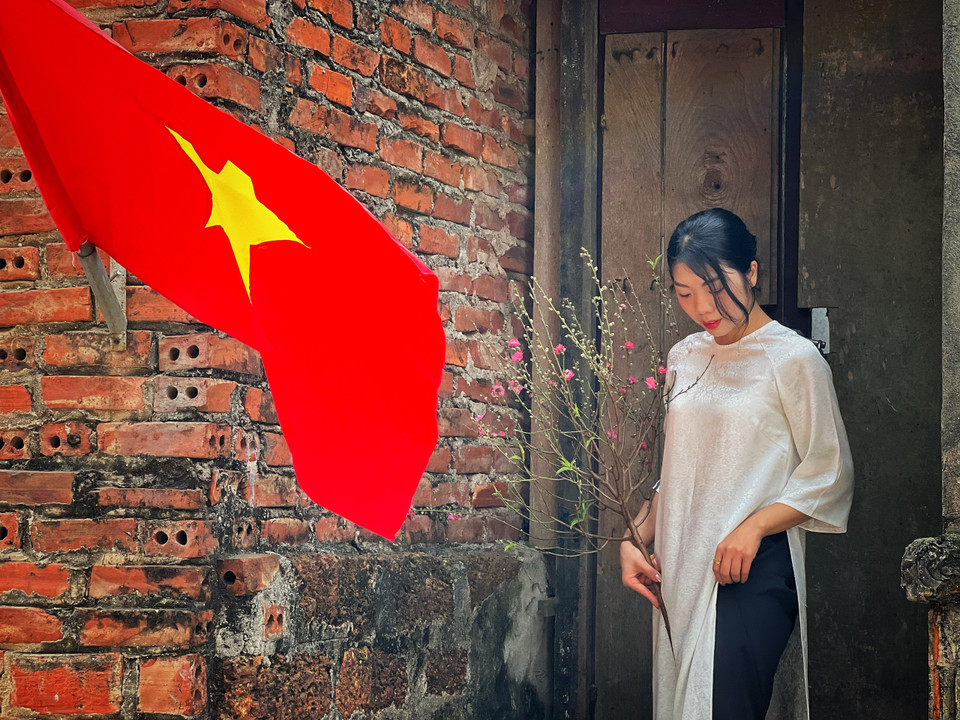 Du khách chọn góc check-in khi đến làng cổ Đường Lâm. (Ảnh: Mai Mai/Vietnam+)