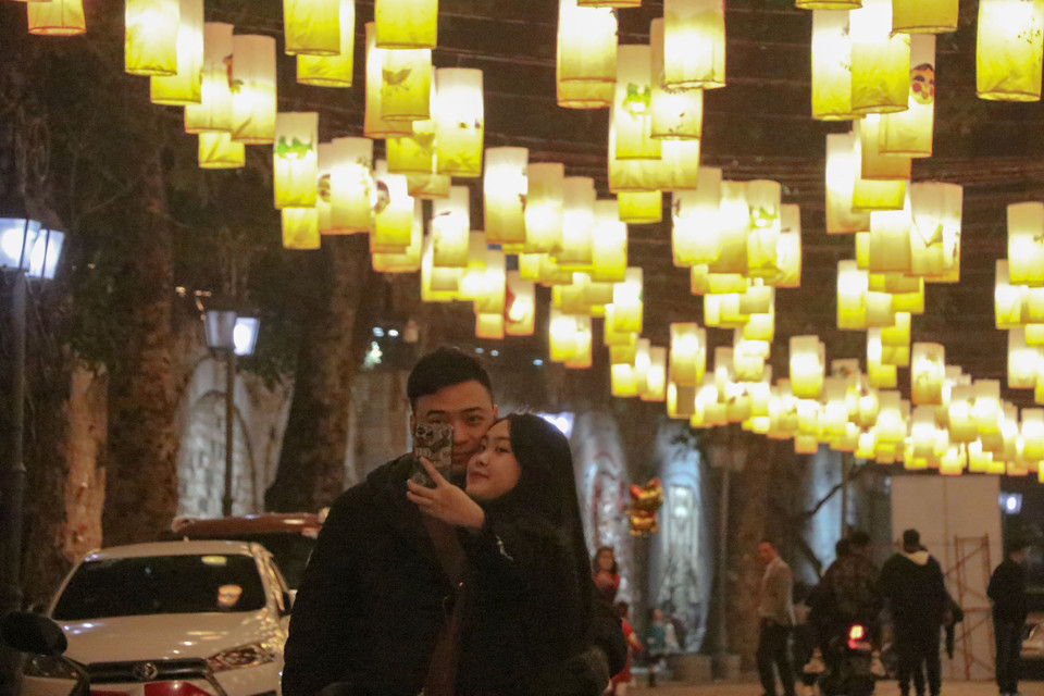 Nhiều cặp đôi trẻ lựa chọn khung nền ảnh là khu vực phố bích họa Phùng Hưng. (Ảnh: Việt Anh/Vietnam+)