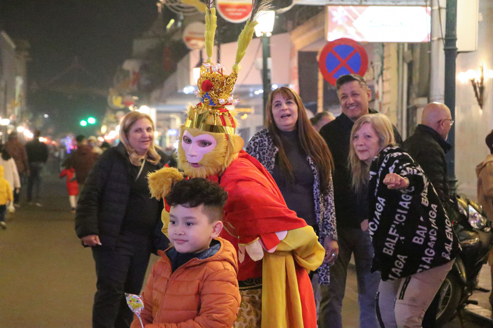 Người dân Thủ đô và du khách nước ngoài ấn tượng với tạo hình Tôn Ngộ Không của một diễn viên tại phố đi bộ hồ Hoàn Kiếm. (Ảnh: Việt Anh/Vietnam+)