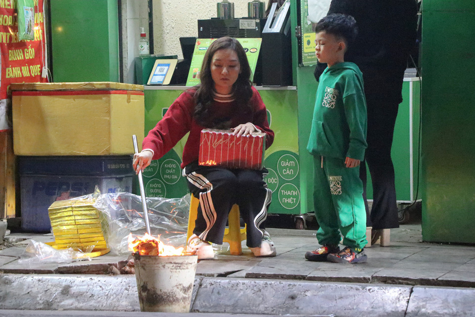 Một số gia đình tranh thủ thời gian trước giao thừa để thực hiện nghi lễ hóa vàng. (Ảnh: Việt Anh/Vietnam+)