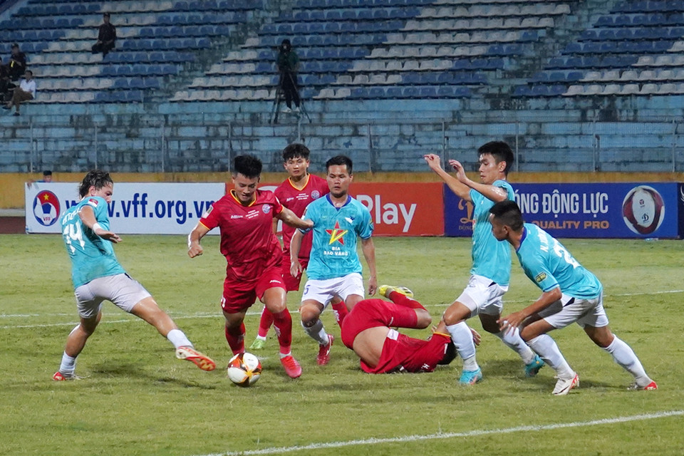 Tiền đạo trẻ Nguyễn Thanh Nhàn 'nhảy múa' giữa vòng vây của các cầu thủ Hồng Lĩnh Hà Tĩnh. (Ảnh: Việt Anh/Vietnam+)