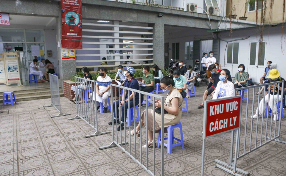 Những người làm việc tại tòa nhà T&amp;T Group chờ lấy mẫu xét nghiệm. (Ảnh: Tuấn Đức/TTXVN)