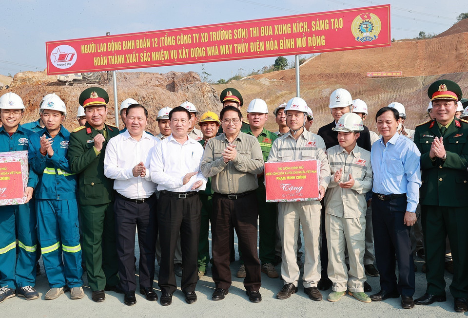 Thủ tướng Phạm Minh Chính tặng quà cho các kỹ sư, công nhân thi công mở rộng Nhà máy Thủy điện Hòa Bình. (Ảnh: Dương Giang/TTXVN)