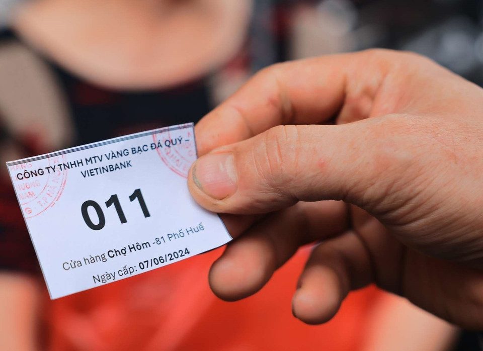 Người dân phải xếp số chờ đến lượt đăng ký mua vàng. (Ảnh: Hoàng Hiếu/TTXVN)