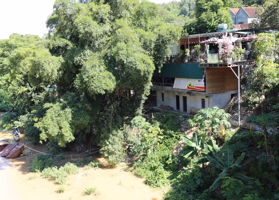 Nhà dân nằm ngay sát chân cầu Cửa Rào (Tương Dương, Nghệ An) bắc qua sông Lam có nguy cơ sạt lở rất cao.(Ảnh: Xuân Tiến/TTXVN)
