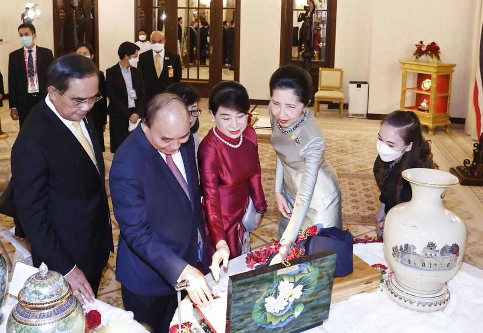 Chủ tịch nước Nguyễn Xuân Phúc và Thủ tướng Vương quốc Thái Lan Prayut Chan-o-cha trao đổi tặng phẩm. (Ảnh: Thống Nhất/TTXVN)