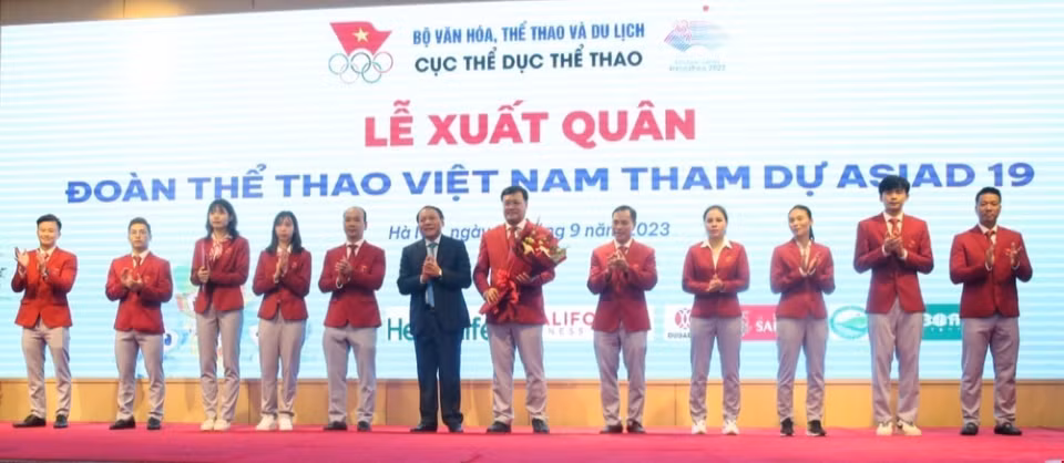Đồng chí Nguyễn Văn Hùng, Bộ trưởng Bộ Văn hoá, Thể thao và Du lịch, Chủ tịch Uỷ ban Olympic Việt Nam tặng hoa đoàn Thể thao Việt Nam.(Ảnh: Tuấn Đức/TTXVN)