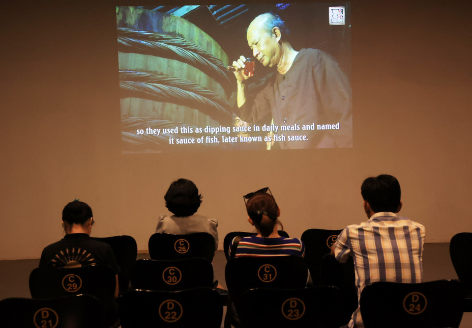 Du khách xem phim tài liệu về nghề làm nước mắm Phan Thiết với 300 năm lịch sử. (Ảnh: Hồng Đạt/TTXVN)