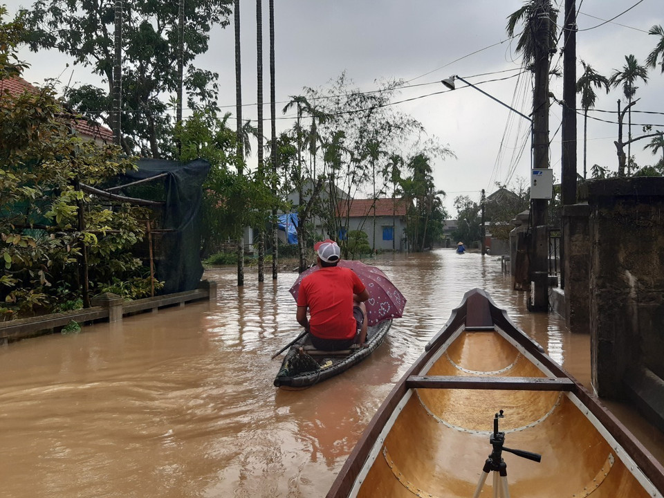 Nước ngập sâu khiến người dân đi lại khó khăn. (Ảnh: Mai Trang/TTXVN)