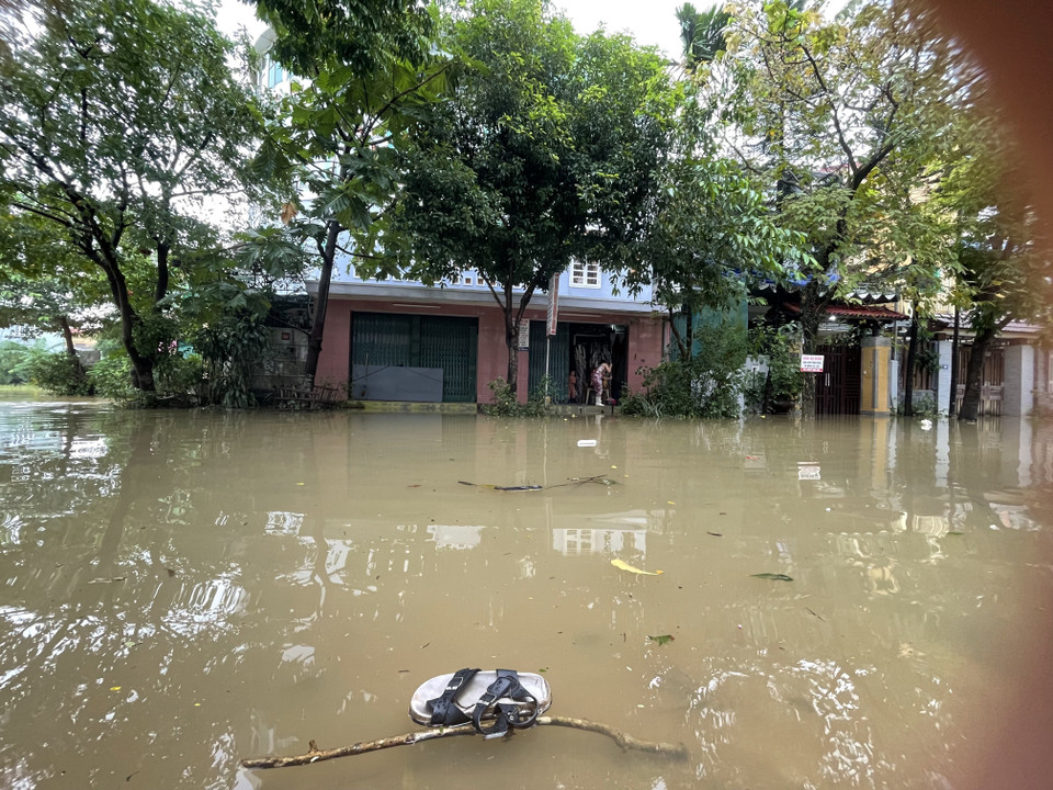 Người dân dọn dẹp nhà cửa khi nước lụt dần hạ. (Ảnh: Mai Trang/TTXVN)