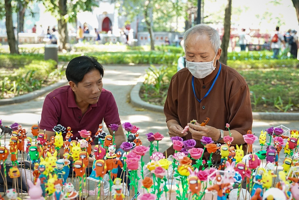 Du khách thích thú đặt mẫu và chứng kiến nghệ nhân nặn trực tiếp. (Ảnh: Khánh Hòa/TTXVN)