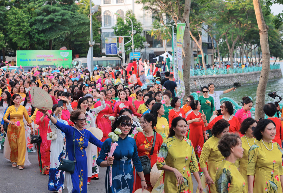 1000 phụ nữ trong tà áo dài truyền thống có hoạ tiết hoa sen dạo bước tại khu vực ven Hồ Tây. (Ảnh: Hoàng Hiếu/TTXVN)