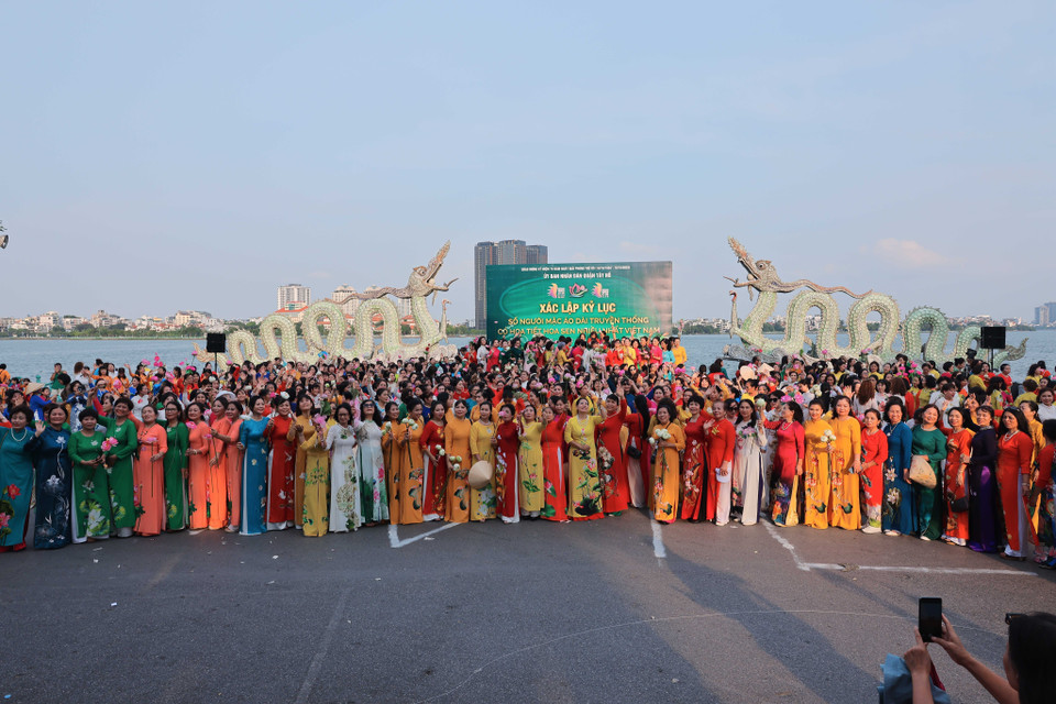 1000 phụ nữ trong tà áo dài truyền thống có hoạ tiết hoa sen tham dự chương trình để xác lập kỷ lục. (Ảnh: Hoàng Hiếu/TTXVN)