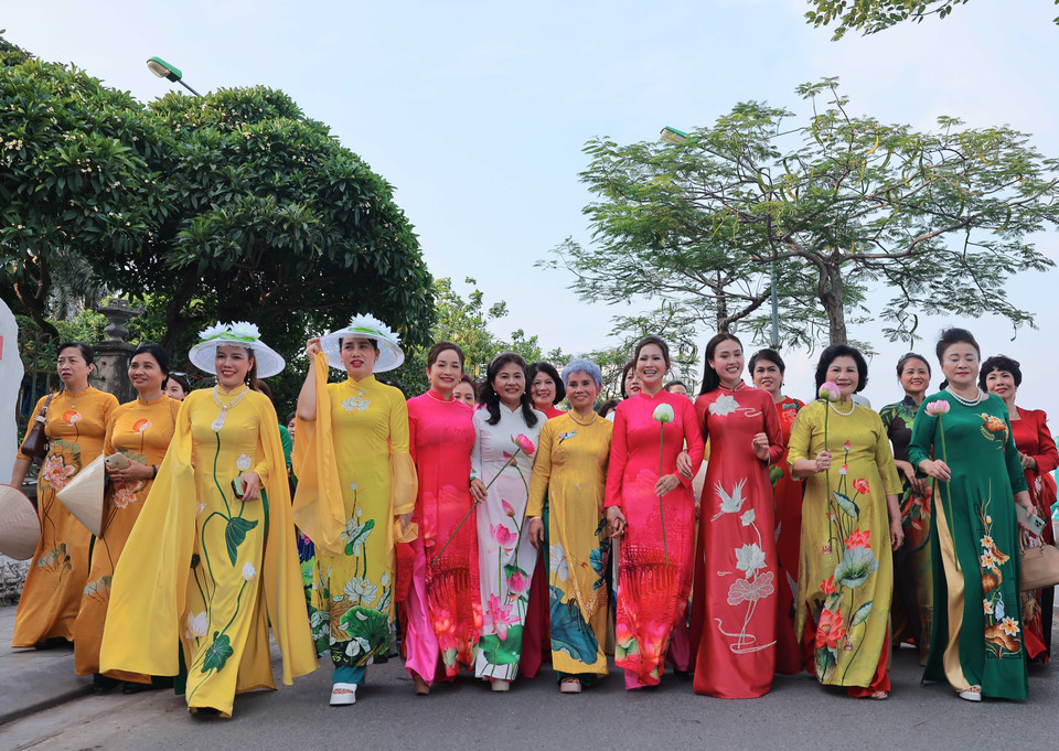 Các đại biểu trong tà áo dài truyền thống dạo bước xác lập kỷ lục. (Ảnh: Hoàng Hiếu/TTXVN)