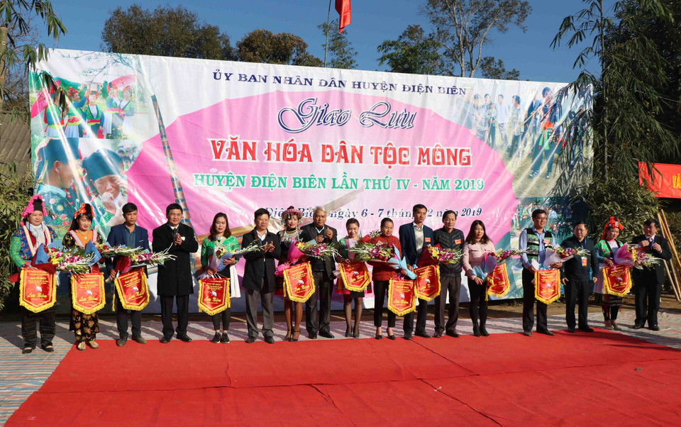 Đại diện lãnh đạo UBND tỉnh, UBND huyện và các sở, ngành trao hoa và cờ lưu niệm cho các đoàn tham dự Ngày hội. (Ảnh: Xuân Tiến/TTXVN)