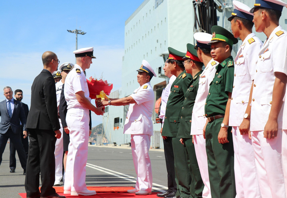 Lãnh đạo Vùng 4 Hải quân tặng hoa cho Trung tá Jacob French, Chỉ huy tàu Regina tại lễ đón. (Ảnh: Tiên Minh/TTXVN)