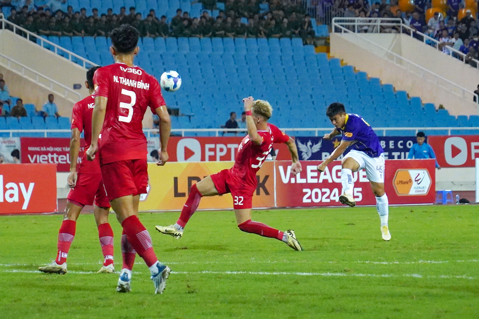 Tiền vệ Lê Văn Xuân (áo tím) "thử vận may" với tình huống sút xa, tuy nhiên bóng không thể vượt qua được sự truy cản của cầu thủ bên phía Thể Công-Viettel. (Ảnh: Việt Anh/Vietnam+)