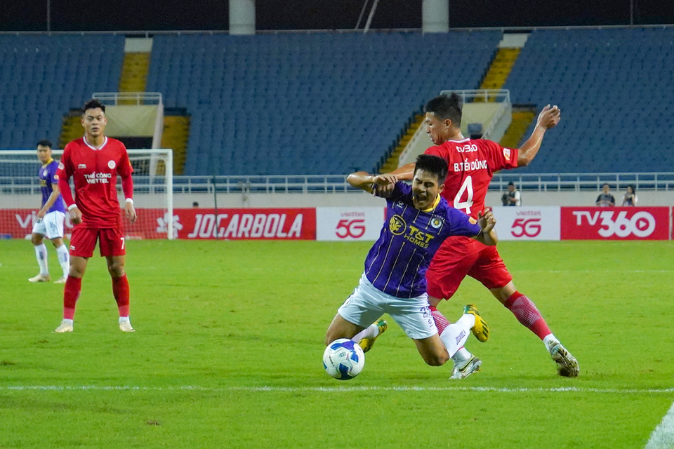 Đội trưởng Bùi Tiến Dũng của Thể Công (số 4) phạm lỗi với tiền vệ Lê Xuân Tú. (Ảnh: Việt Anh/Vietnam+)