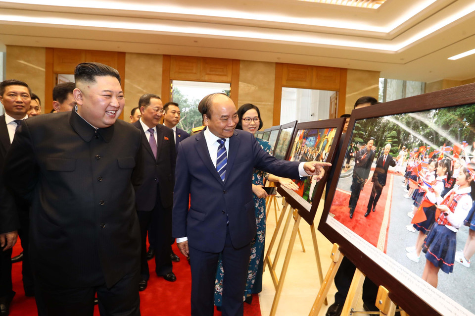 Thủ tướng Nguyễn Xuân Phúc giới thiệu với Chủ tịch Triều Tiên Kim Jong-un những bức ảnh tiêu biểu về quan hệ giữa hai nước trong 69 năm qua, kể từ ngày thiết lập quan hệ ngoại giao 31/1/1950, do các phóng viên ảnh của TTXVN chụp. (Ảnh: Thống Nhất/TTXVN)