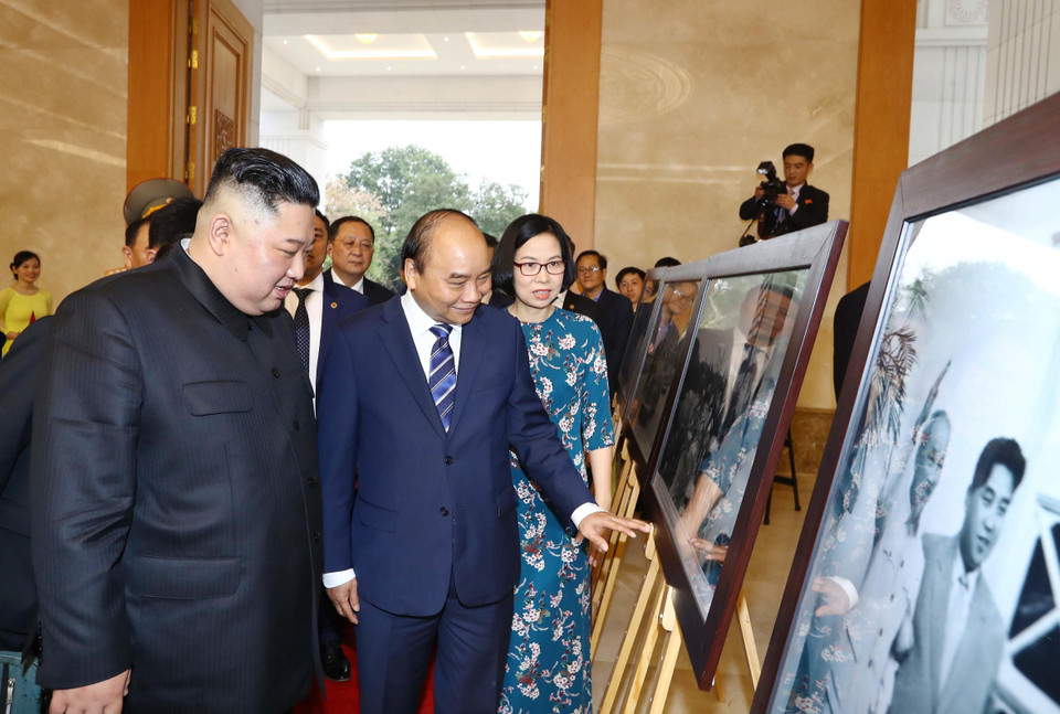 Thủ tướng Nguyễn Xuân Phúc giới thiệu với Chủ tịch Triều Tiên Kim Jong-un những bức ảnh tiêu biểu về quan hệ giữa hai nước trong 69 năm qua, kể từ ngày thiết lập quan hệ ngoại giao 31/1/1950, do các phóng viên ảnh của TTXVN chụp. (Ảnh: Thống Nhất/TTXVN)