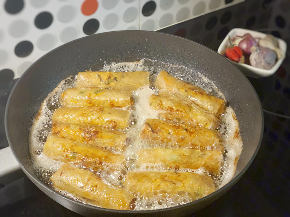 Cho dầu ăn vào chảo và rán nem vàng từng mặt. Với loại vỏ bánh đa nem này nem rán xong có thể giữ được lớp vỏ giòn rụm trong khoảng 1 tiếng. (Ảnh: Mai Mai/Vietnam+)