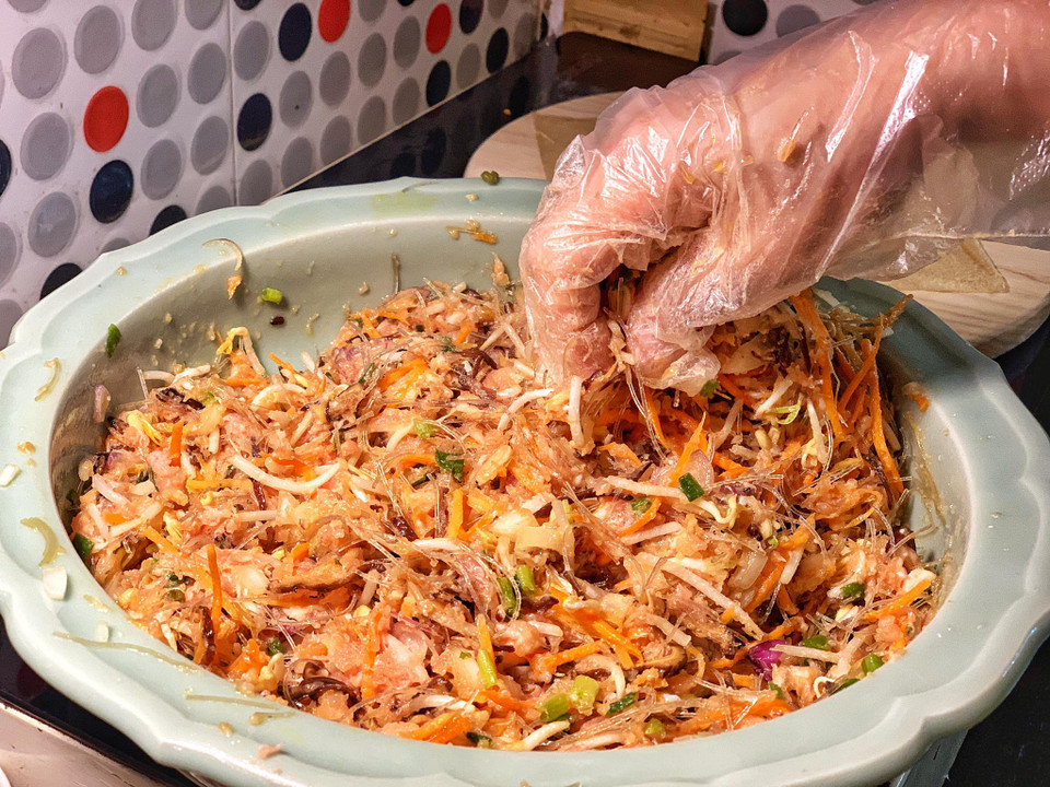 Trộn đều cùng hạt nêm, chút tiêu ướp trong khoảng 10 phút. Lưu ý chỉ trộn với lòng đỏ trứng gà, bỏ lòng trắng để hỗ hợp không bị chảy nước ướt bánh đa nem. (Ảnh: Mai Mai/Vietnam+)