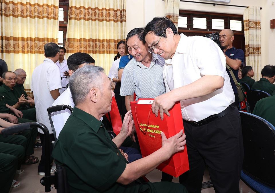 Thủ tướng Phạm Minh Chính tặng quà cho thương, bệnh binh đang điều trị tại Trung tâm điều dưỡng thương binh Kim Bảng. (Ảnh: Dương Giang/TTXVN)