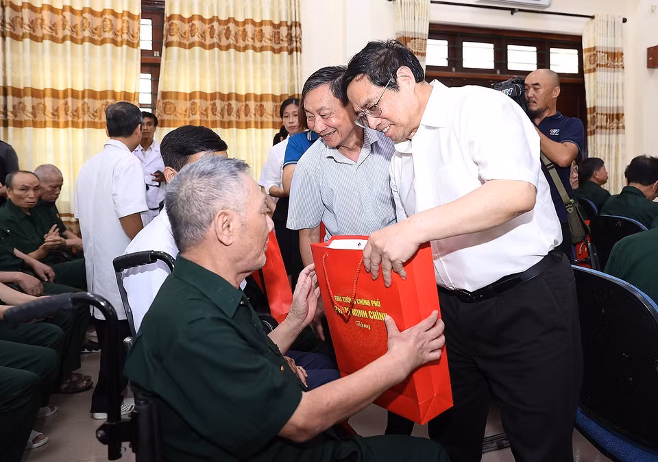 Thủ tướng Phạm Minh Chính tặng quà cho thương, bệnh binh đang điều trị tại Trung tâm điều dưỡng thương binh Kim Bảng. (Ảnh: Dương Giang/TTXVN)