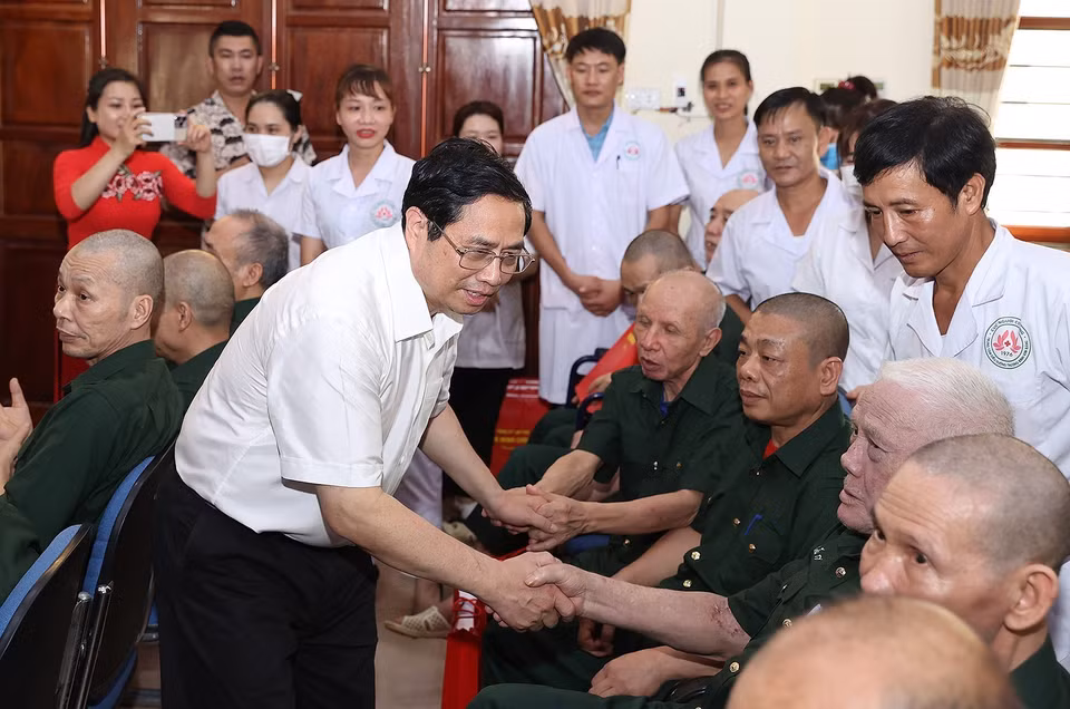 Thủ tướng Phạm Minh Chính ân cần thăm hỏi các thương, bệnh binh điều trị tại Trung tâm điều dưỡng thương binh Kim Bảng. (Ảnh: Dương Giang/TTXVN)