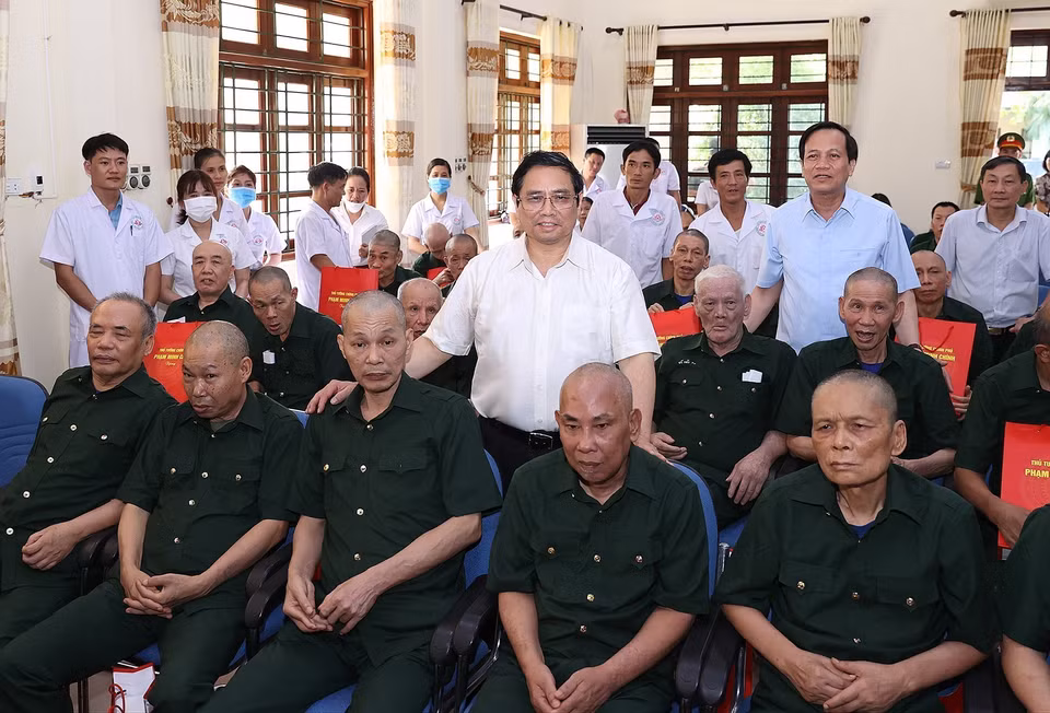 Thủ tướng Phạm Minh Chính chụp ảnh cùng các thương, bệnh binh đang điều trị tại Trung tâm điều dưỡng thương binh huyện Kim Bảng. (Ảnh: Dương Giang/TTXVN)