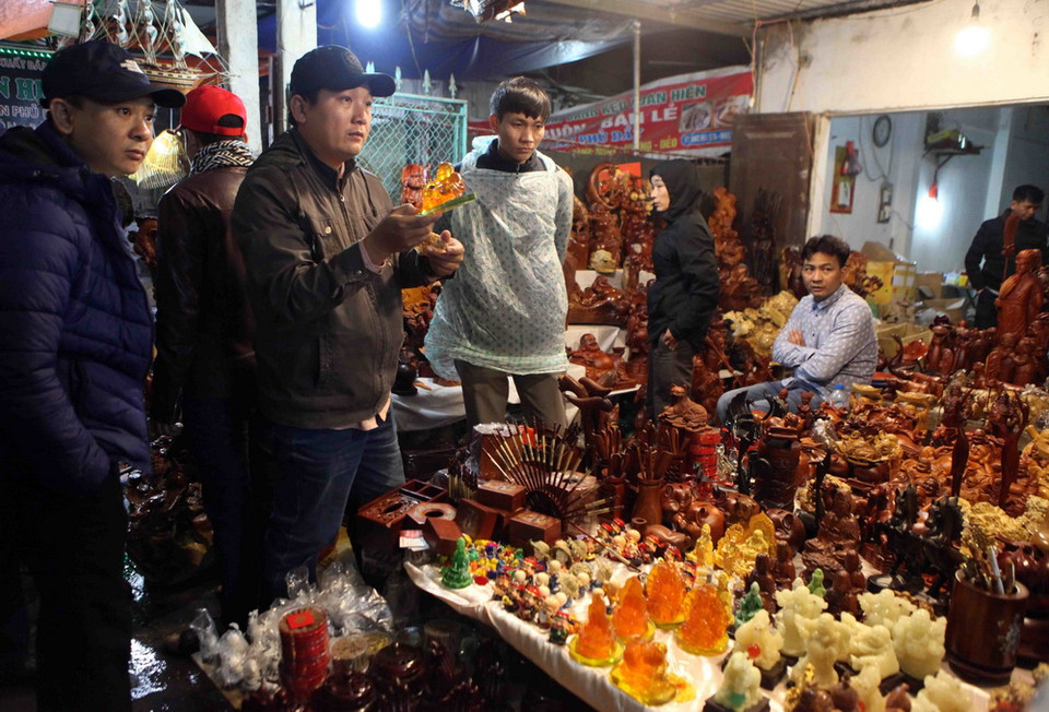 Du khách thập phương chọn mua những vật dụng lấy may đầu xuân năm mới. (Ảnh: Quý Trung/TTXVN)