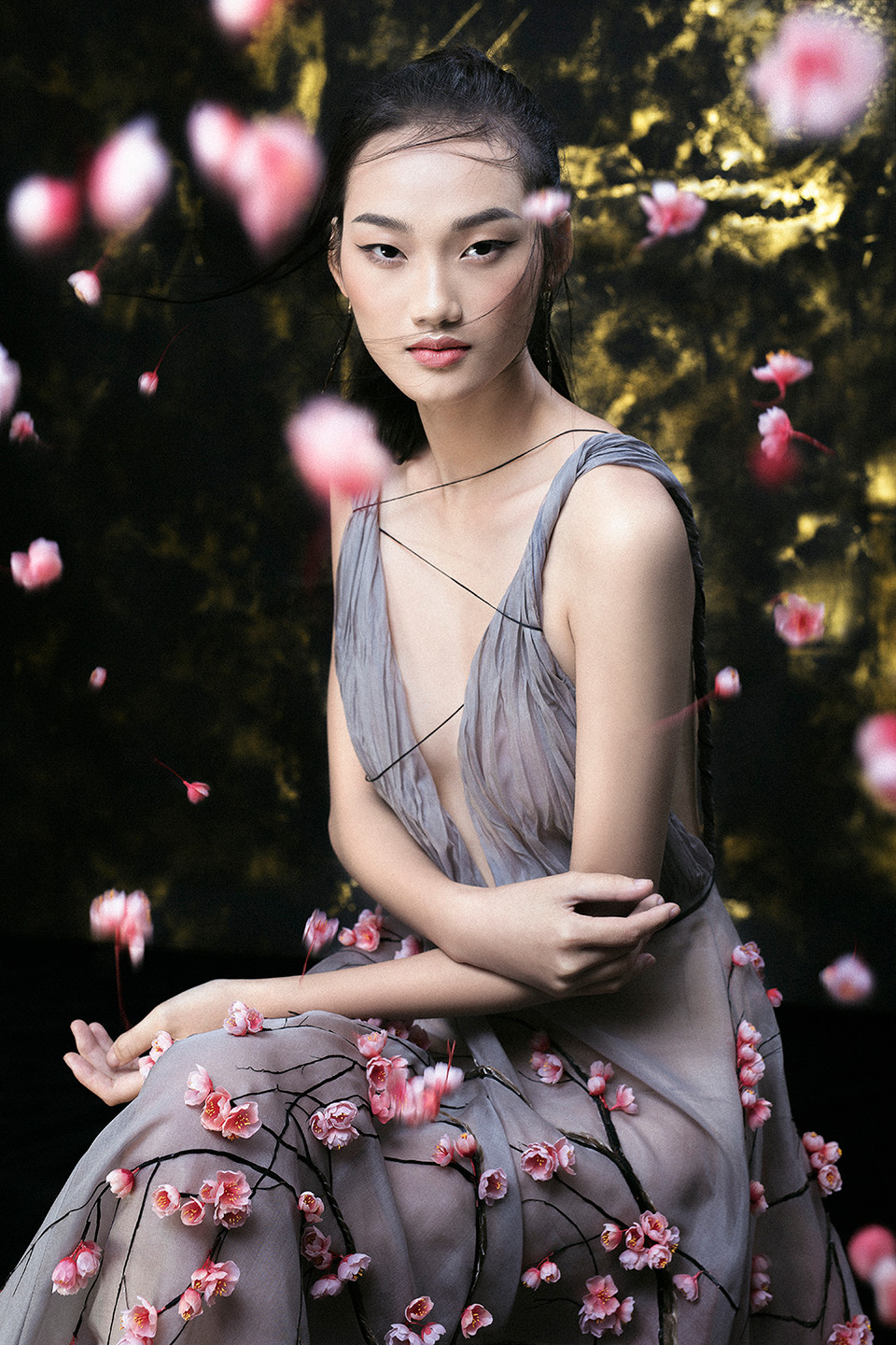 Sau đó cắt dán từng chiếc lông vũ và bố trí tạo khối để cho ra tác phẩm rừng thân cây chạy dọc thân váy. (Ảnh: Shin Vox/Vietnam+)