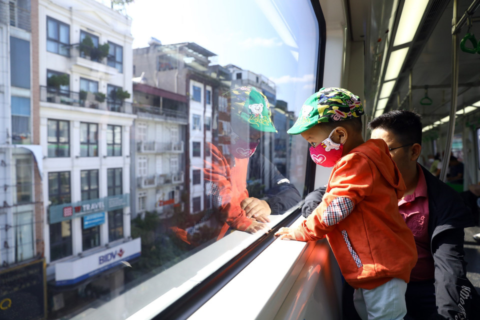 Trẻ nhỏ hứng khởi khi được bố đưa đi chơi bằng tàu điện trên cao. (Ảnh: Huy Hùng/TTXVN)