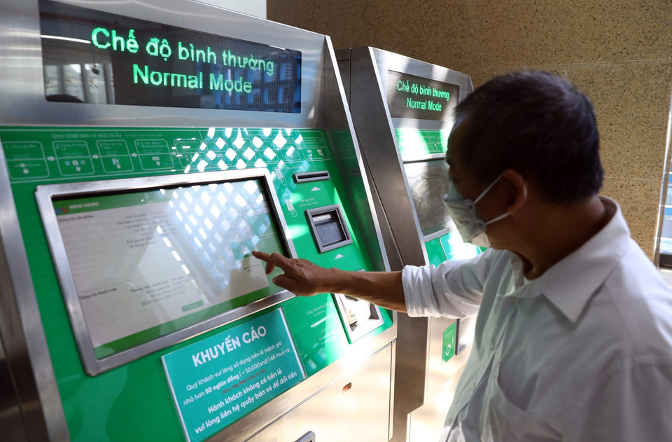 Người dân mua vé tàu bằng máy bán vé tự động. Vé gồm các loại: Vé lượt (8.000 - 15.000 đồng/lượt, tính theo quãng đường đi), vé ngày (30.000 đồng/vé, không hạn chế lượt đi).(Ảnh: Huy Hùng/TTXVN)