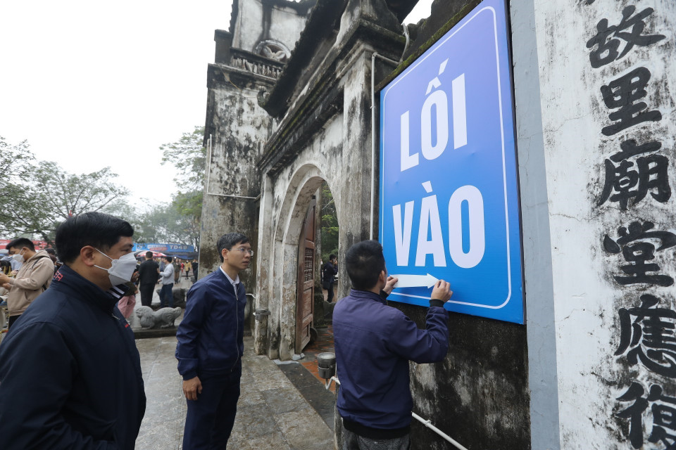 Ban tổ chức dán biển chỉ dẫn cho người dân và du khách thập phương đến lễ hội. (Ảnh: Minh Quyết/TTXVN)