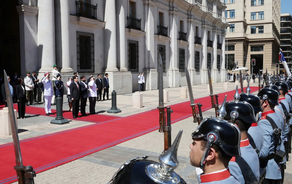 Chủ tịch nước Lương Cường và Tổng thống Chile Gabriel Boric Font thực hiện nghi lễ chào cờ. (Ảnh: Lâm Khánh/TTXVN)