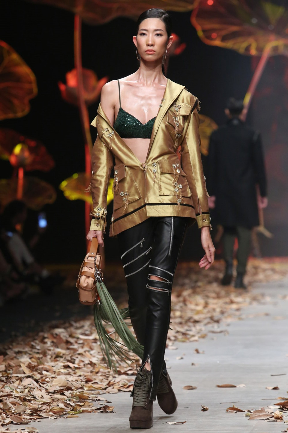 Điểm nhấn kim loại, đính đá, sequin, tua rua tinh xảo được đính ở những chi tiết đai áo, nắp hộp to bản. 