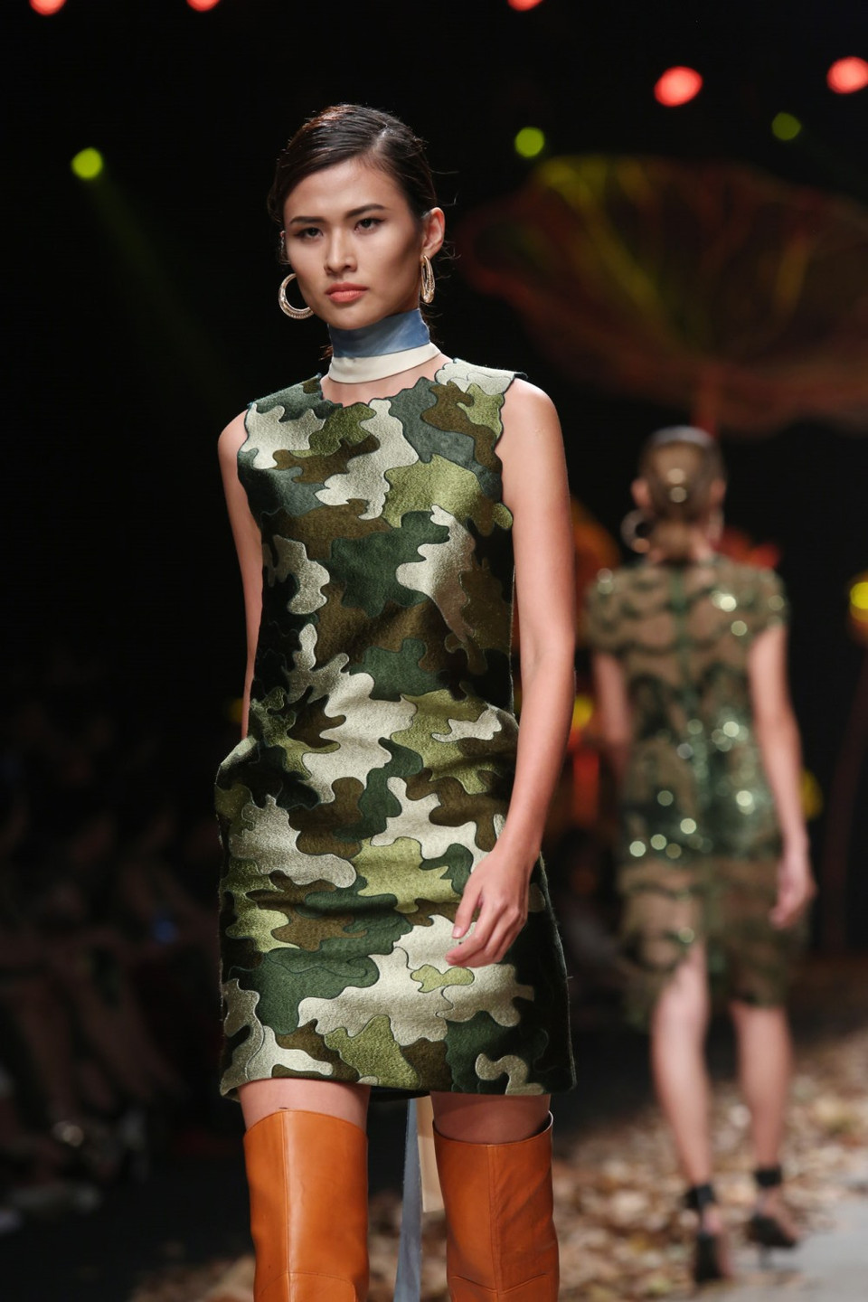 Lá khô trải dọc sân khấu không chỉ tăng thêm hiệu ứng thị giác cho người xem mà còn thể hiện sự đồng điệu với tinh thần quân đội của 'Military.'