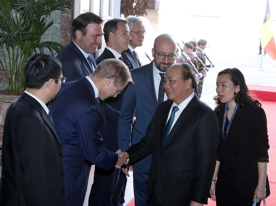 Thủ tướng Nguyễn Xuân Phúc bắt tay các quan chức Bỉ tham dự lễ đón. (Ảnh: Thống Nhất/TTXVN)