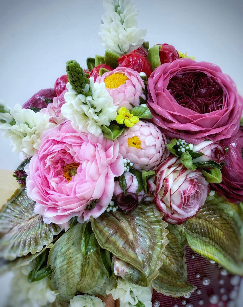 Những chiếc bánh không chỉ là bánh mà giống như những lẵng hoa tươi sống động và có hồn. (Ảnh: Tố Linh/Vietnam+)