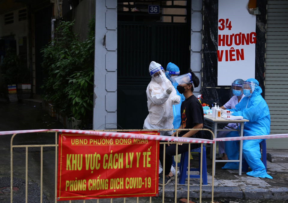 Người dân trong khu vực phong tỏa tạm thời thuộc phường Đồng Nhân được lấy mẫu xét nghiệm ngay trong chiều 24/9. (Ảnh: Hoàng Hiếu/TTXVN)
