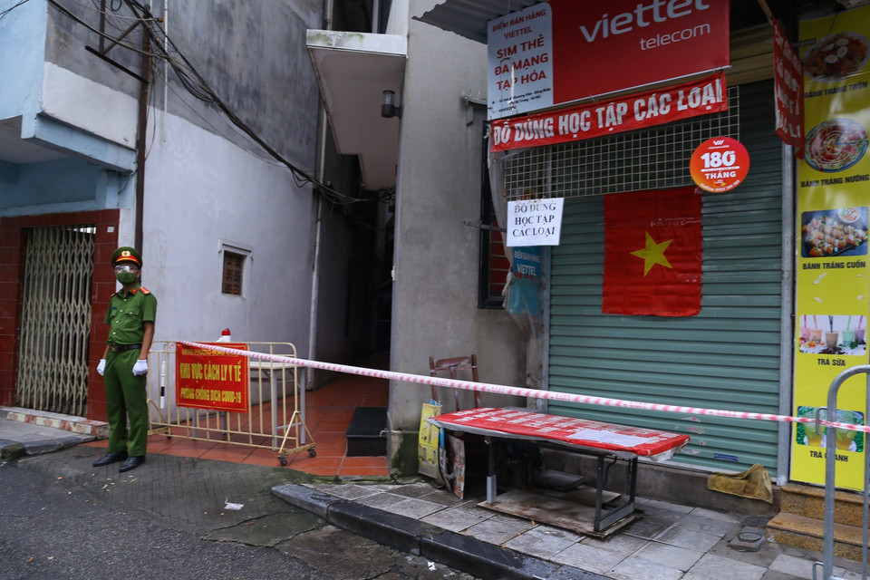 Công an phường Đồng Nhân trực tại khu vực bị phong tỏa tạm thời. (Ảnh: Hoàng Hiếu/TTXVN)