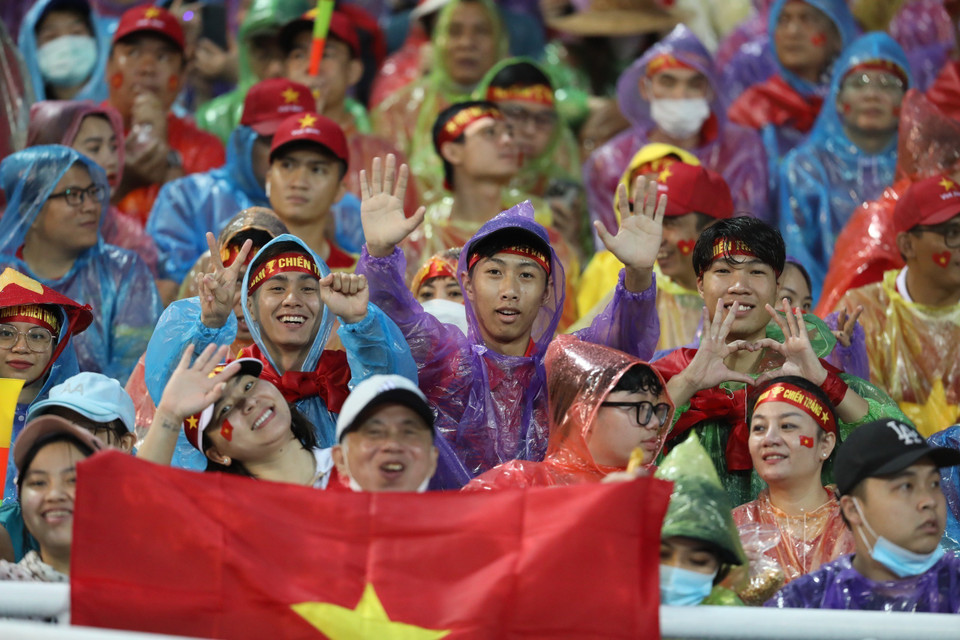 Cổ động viên Việt Nam đội mưa đến sân vận động Mỹ Đình để cổ vũ cho U23 thi đấu. (Ảnh: Minh Quyết/TTXVN)